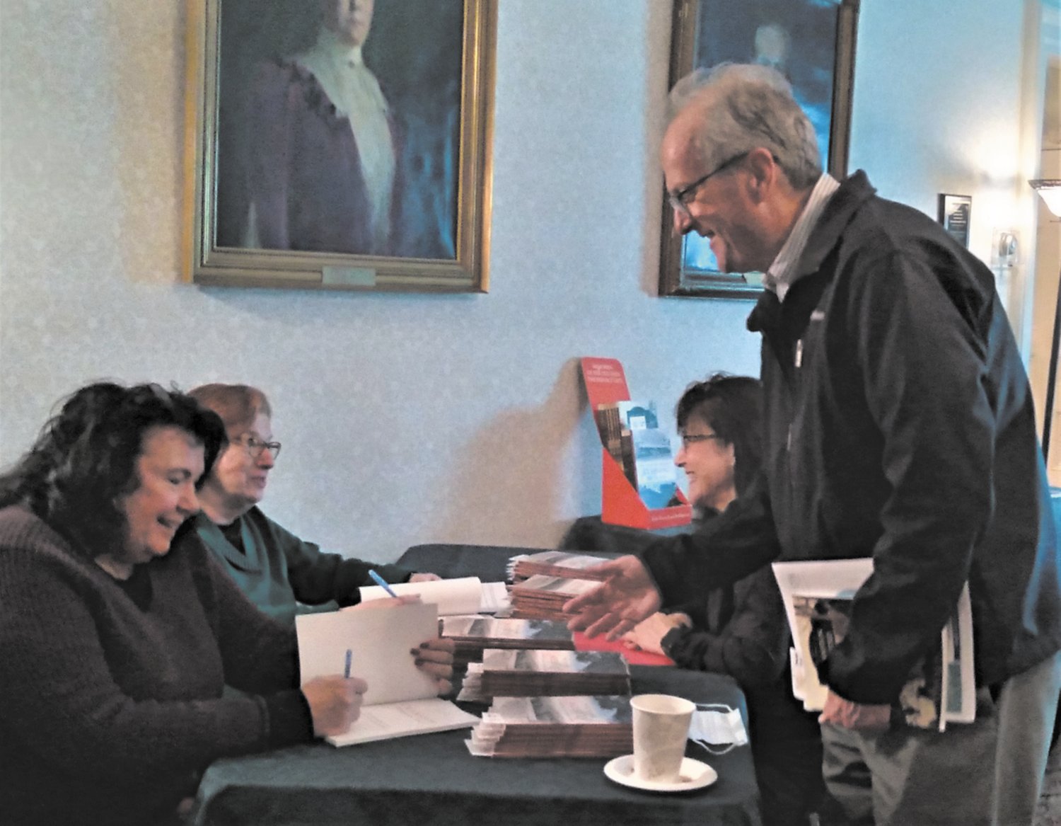 SIGNED PERSONALLY: Co-authors, Janet Ragno and Sandra Moyer, sign copies of their book, “Cranston Through Time,” for Debra Brown and John O’Leary on March 15. All proceeds go to benefit the Cranston Historical Society. Copies can be purchased through the Society’